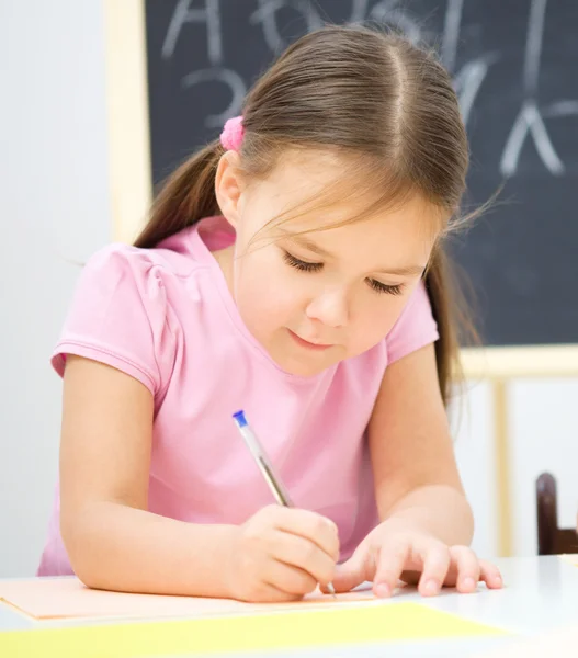 La bambina sta scrivendo usando una penna — Foto Stock