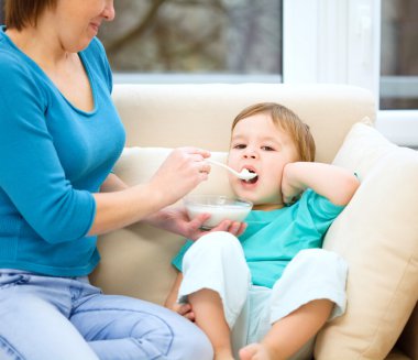 sevimli küçük çocuk kaşık kullanarak besleniyor