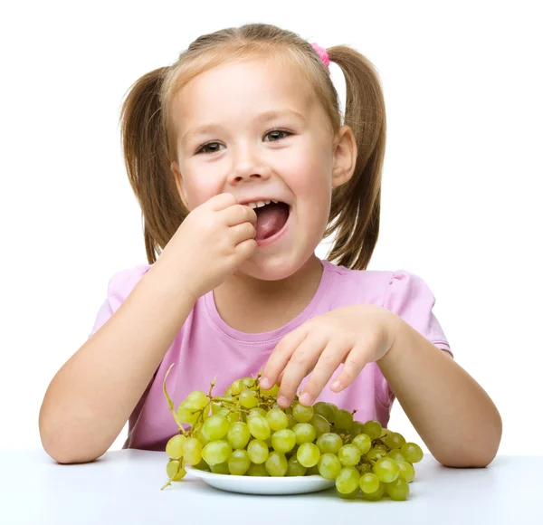 Little girl is eating grapes — Stock Photo, Image