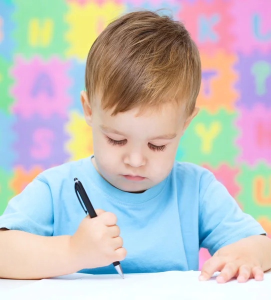 Little boy is writing on his copybook — Stock Photo, Image