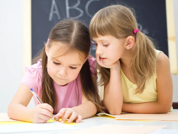 Kleine meisjes zijn schrijven met een pen — Stockfoto