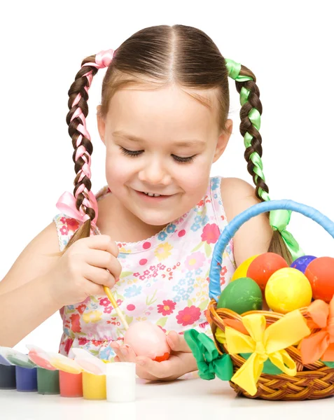 Niña está pintando huevos preparándose para Pascua —  Fotos de Stock