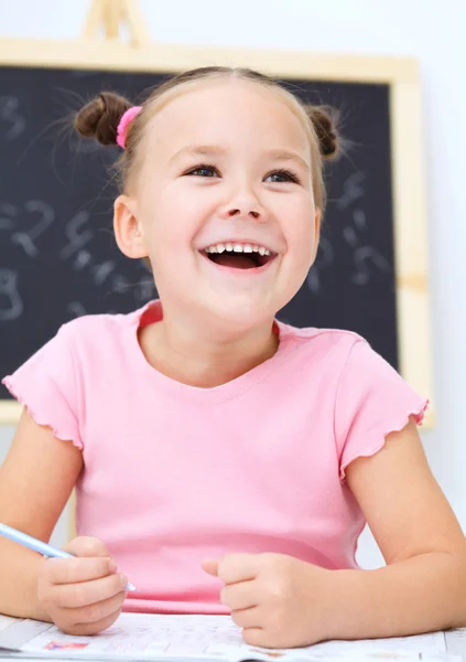 La niña está escribiendo usando un bolígrafo — Foto de Stock