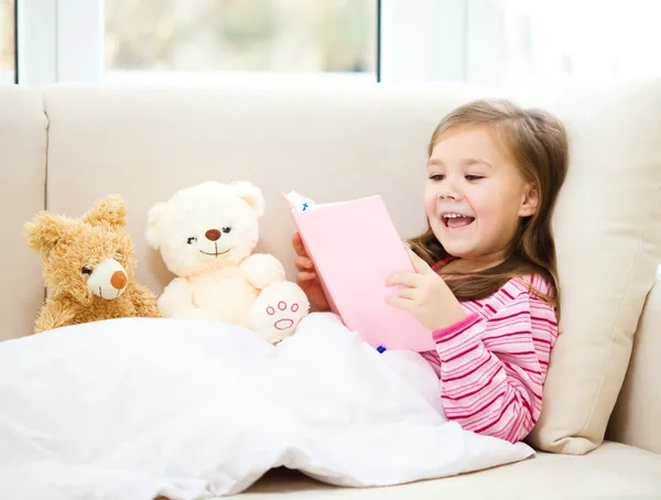 Niña está leyendo una historia para sus osos de peluche — Foto de Stock