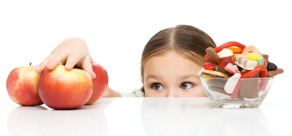 Niña está alcanzando manzana —  Fotos de Stock