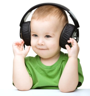 sevimli küçük çocuk kulaklık kullanarak müzik keyfi