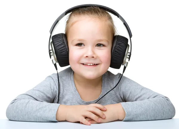 Niña está disfrutando de la música usando auriculares —  Fotos de Stock