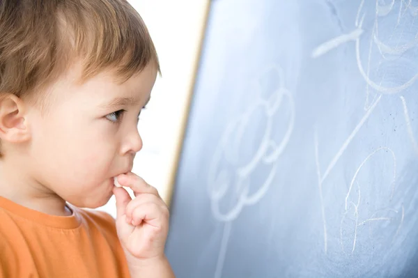 Little boy is biting chalk — Stock Photo, Image