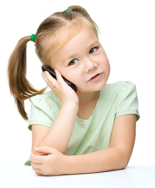 Cute little girl is talking on a cell phone — Stock Photo, Image