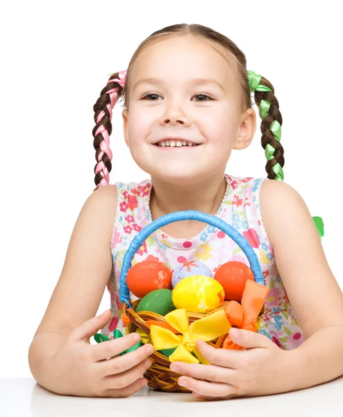 Little girl with basket full of colorful eggs — Stock Photo, Image