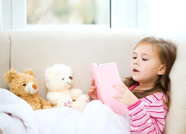 Niña está leyendo una historia para sus osos de peluche — Foto de Stock