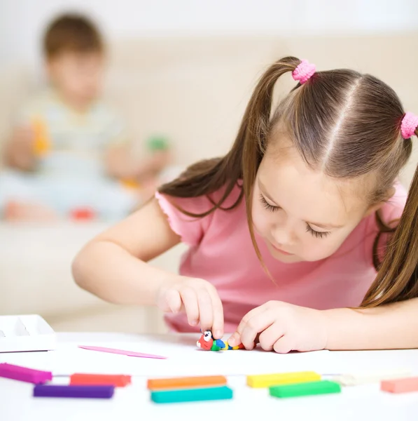 Klein meisje rommelt met plasticine — Stockfoto