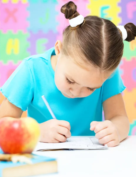 La niña está escribiendo usando un bolígrafo —  Fotos de Stock