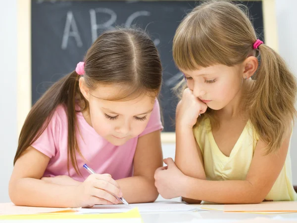 Las niñas están escribiendo usando un bolígrafo —  Fotos de Stock