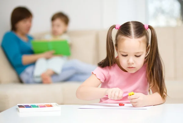 Klein meisje rommelt met plasticine — Stockfoto