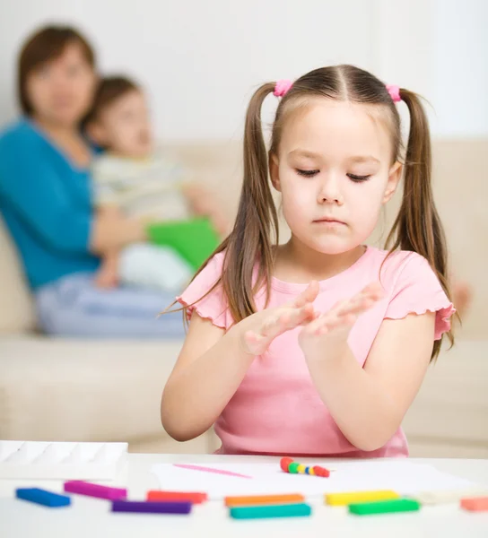 Menina está brincando com plasticina — Fotografia de Stock