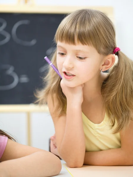 La niña está escribiendo usando un bolígrafo —  Fotos de Stock