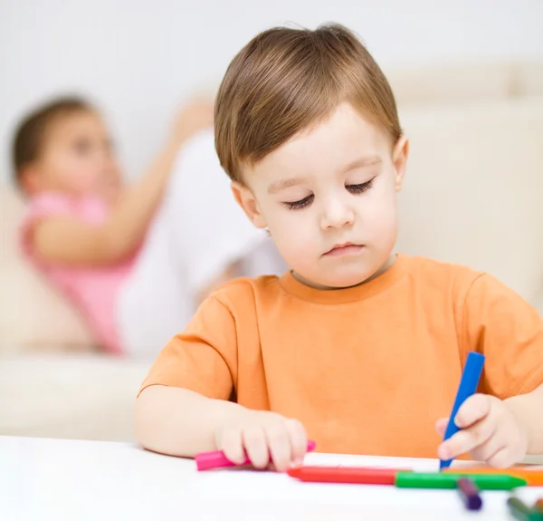 Kleiner Junge zeichnet auf weißem Papier — Stockfoto
