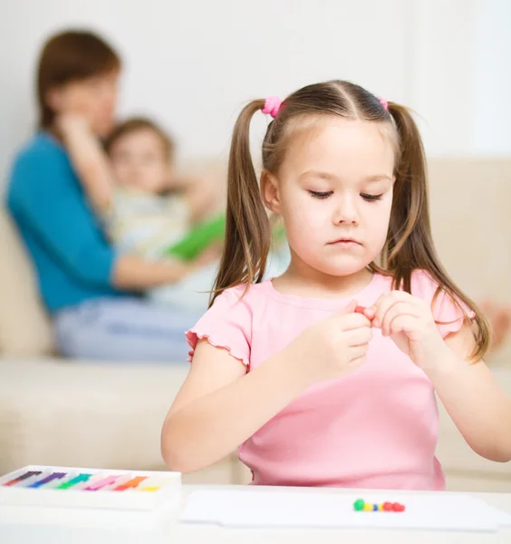 Klein meisje rommelt met plasticine — Stockfoto