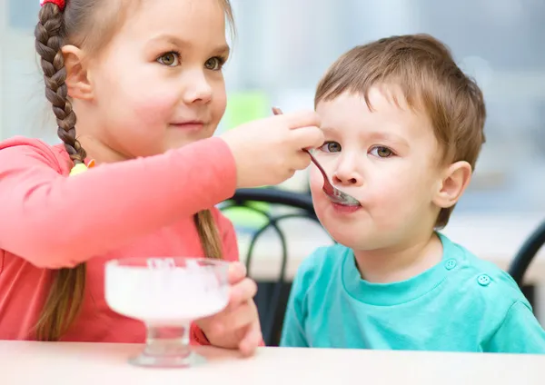 Chica está alimentando a su hermano pequeño con helado — Foto de Stock