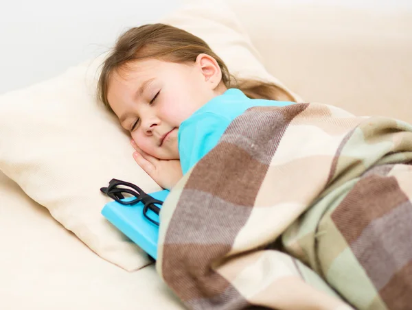 Meisje slaapt met haar boek en glazen — Stockfoto