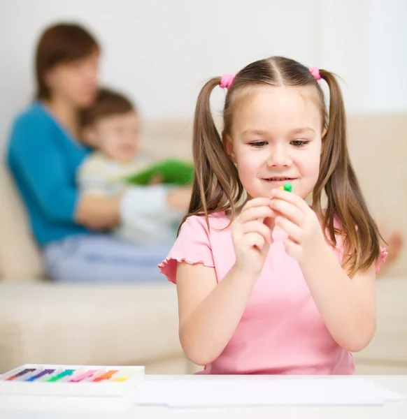 Klein meisje rommelt met plasticine — Stockfoto