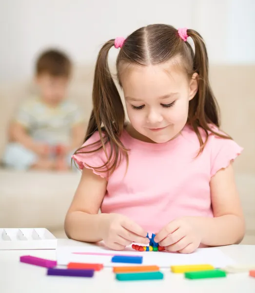 Little girl is playing with plasticine — Stock Photo, Image