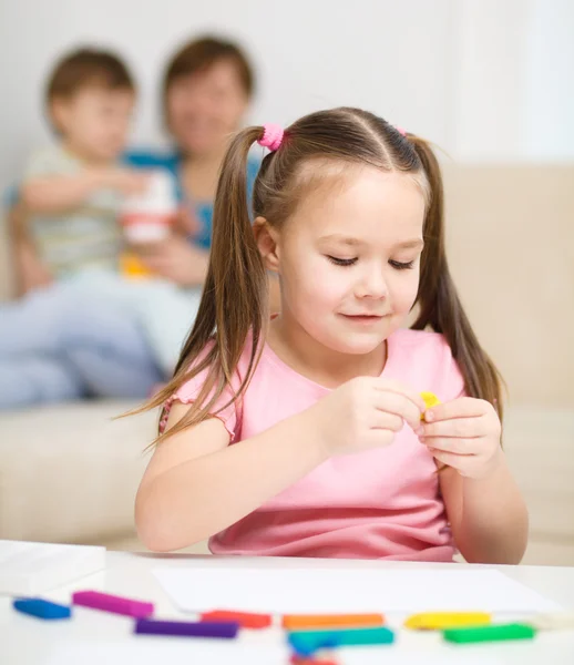 Little girl is playing with plasticine — Stock Photo, Image