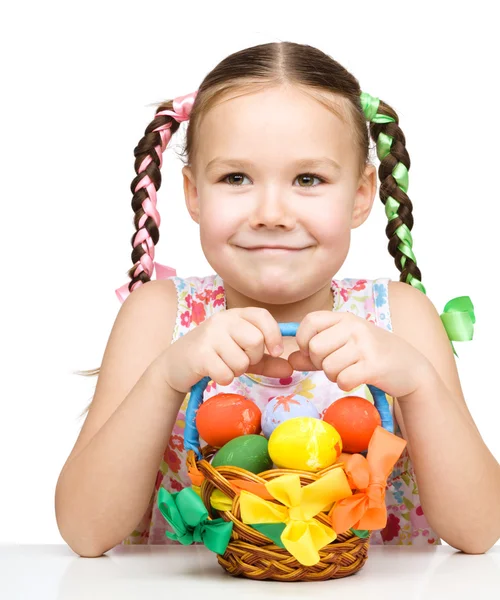Meisje met mand vol kleurrijke eieren — Stockfoto