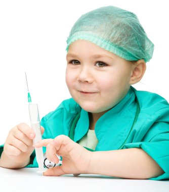 sevimli küçük kız doktor şırınga ile oynuyor