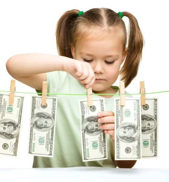 Cute little girl is playing with paper money — Stock Photo, Image