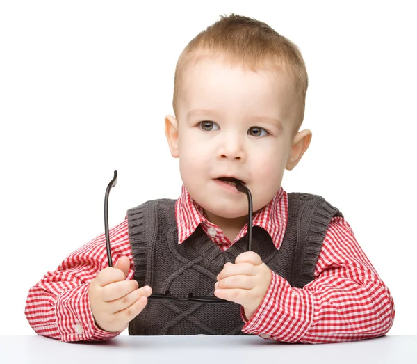 Маленький ребенок кусает очки — стоковое фото