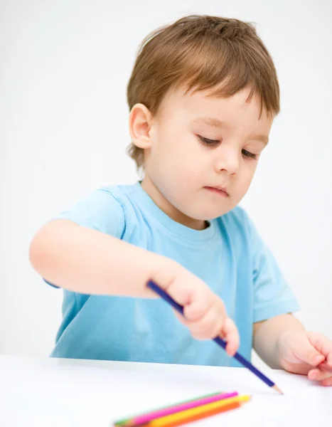 Little boy is drawing on white paper Stock Image