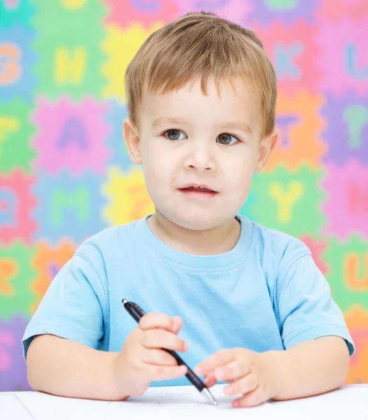 Little boy is writing on his copybook — Stock Photo, Image