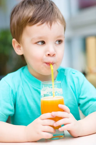 Liten pojke med glas apelsinjuice — Stockfoto