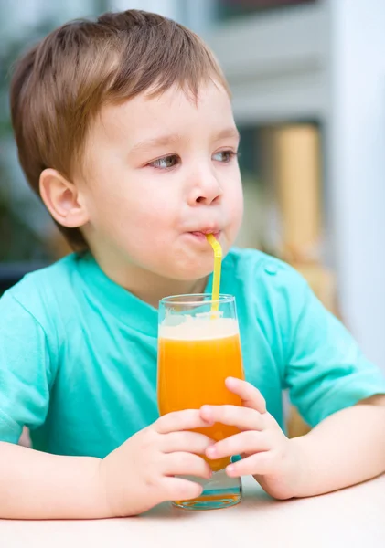 Little boy with glass of orange juice — Stock Photo, Image