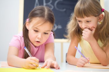 küçük kızlar bir kalem kullanarak yazma