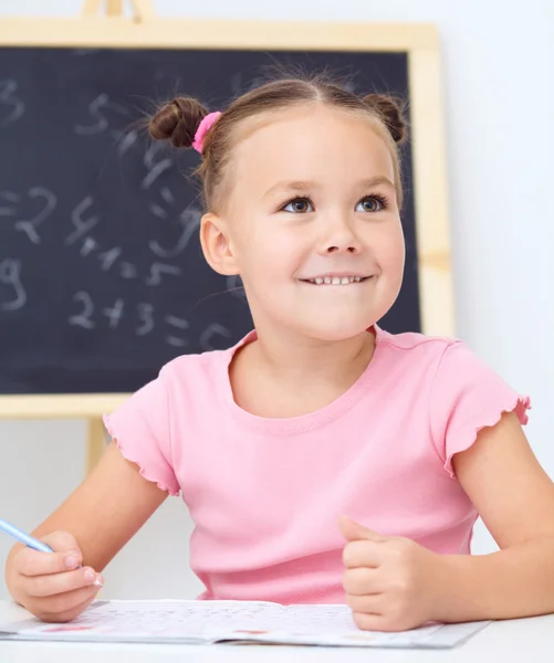 La niña está escribiendo usando un bolígrafo —  Fotos de Stock