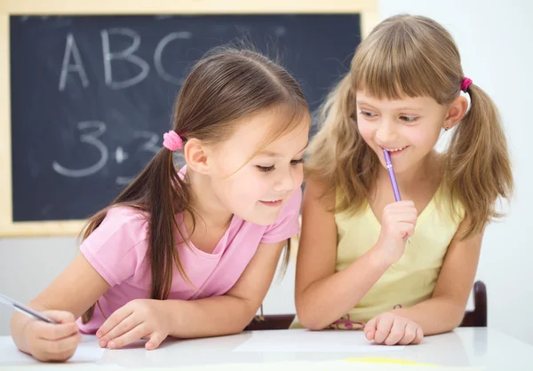 Le bambine stanno scrivendo usando una penna — Foto Stock