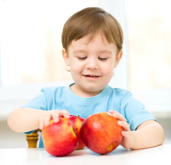 Porträtt av en glad liten pojke med äpplen — Stockfoto