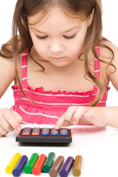 Маленькая девочка играет с калькулятором — стоковое фото