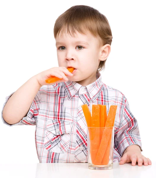 Little boy is eating carrot — Stock Photo, Image