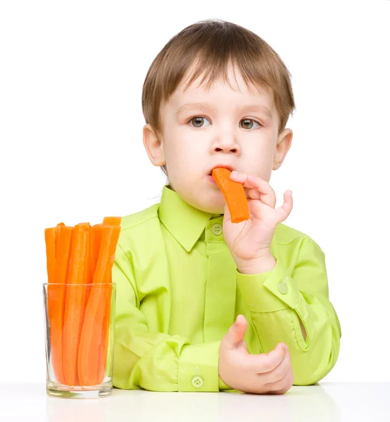 Little boy is eating carrot — Stock Photo, Image
