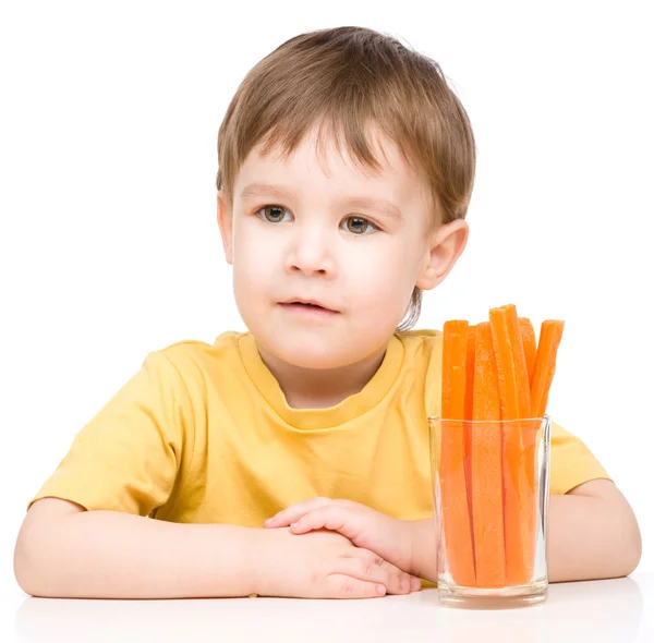 Little boy is eating carrot — Stock Photo, Image