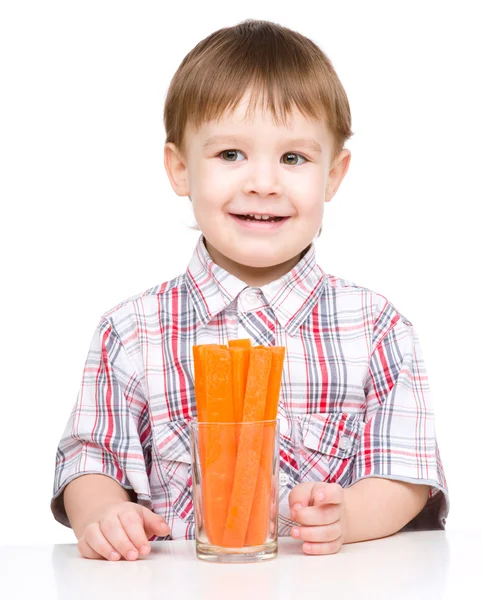 Menino está comendo cenoura — Fotografia de Stock