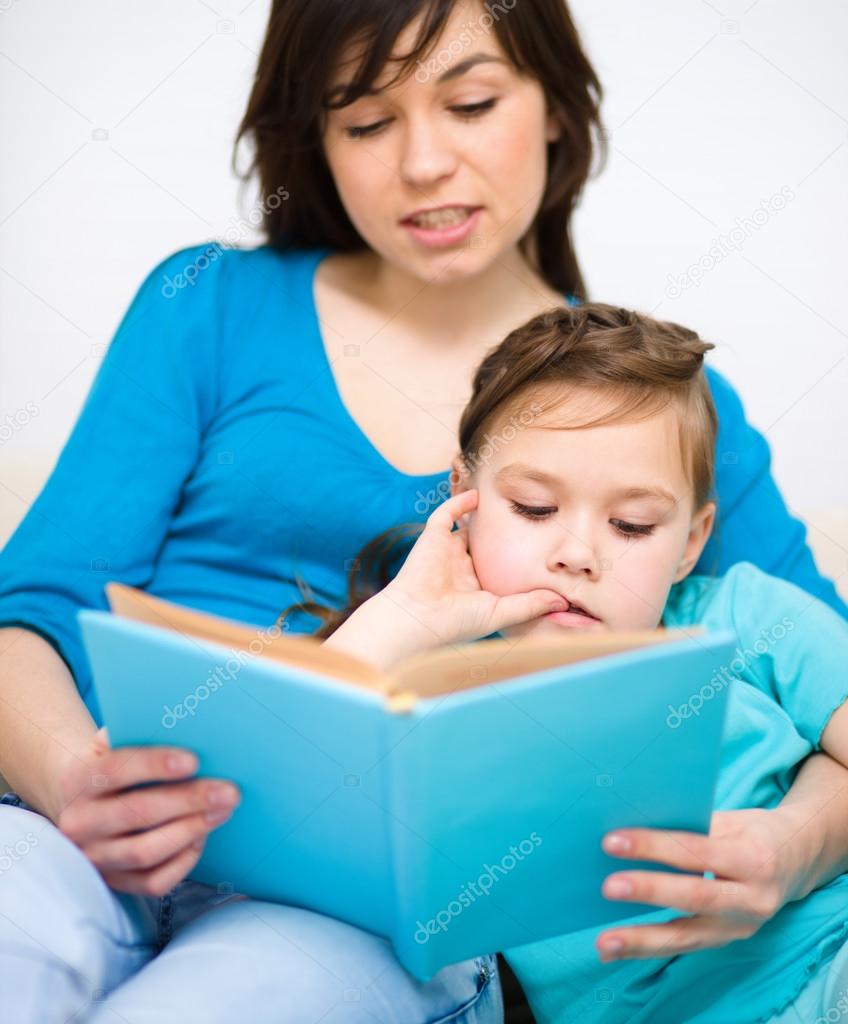 Mother is reading book with her daughter