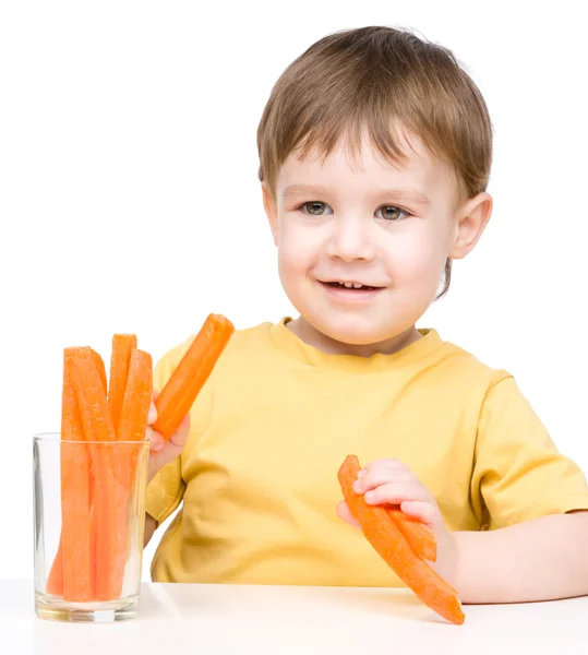 Little boy is eating carrot — Stock Photo, Image