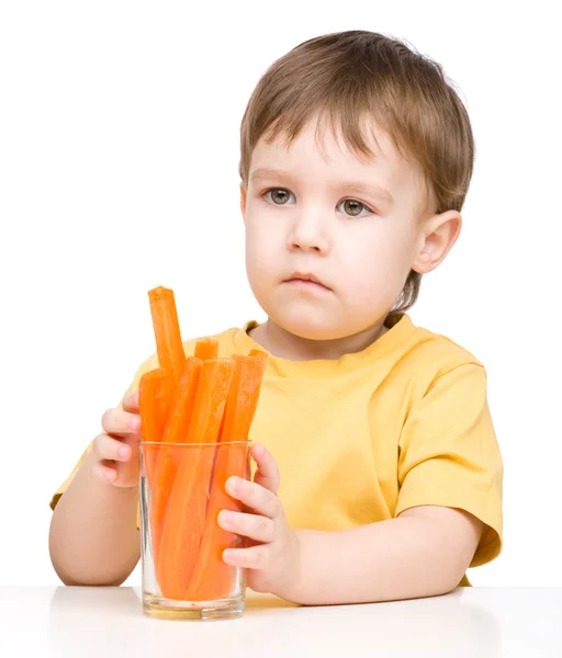 Little boy is eating carrot — Stock Photo, Image