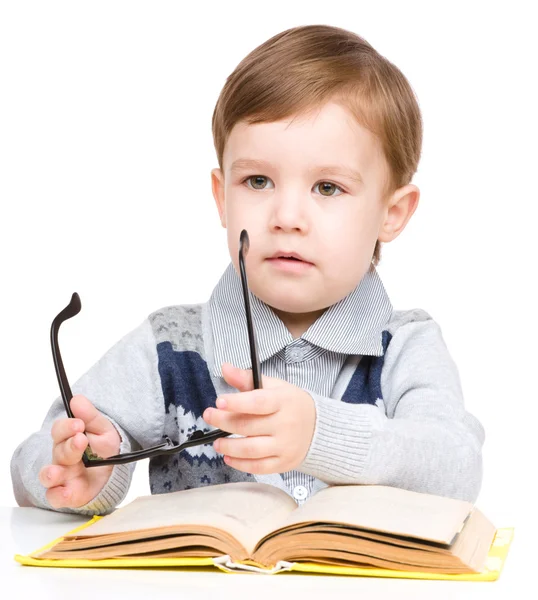 Criança brinca com livro — Fotografia de Stock