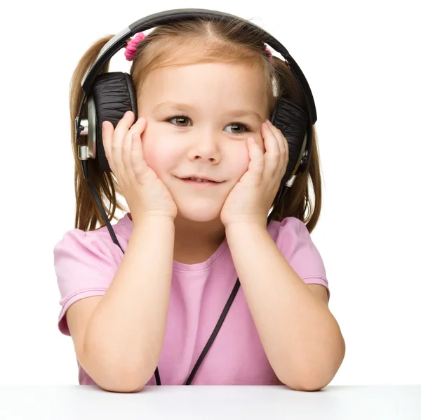 Gadis kecil menikmati musik menggunakan headphone — Stok Foto